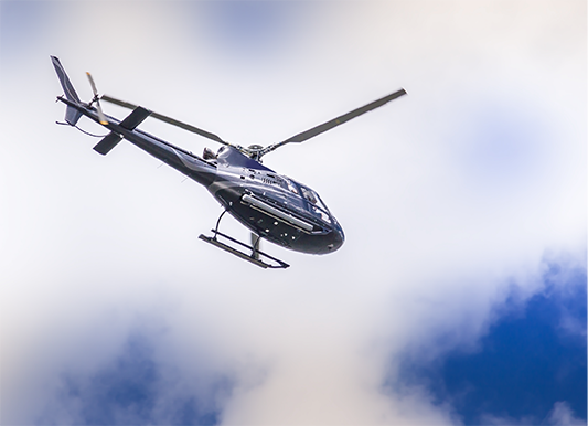 image of helicopter with cloudy blue sky in the background